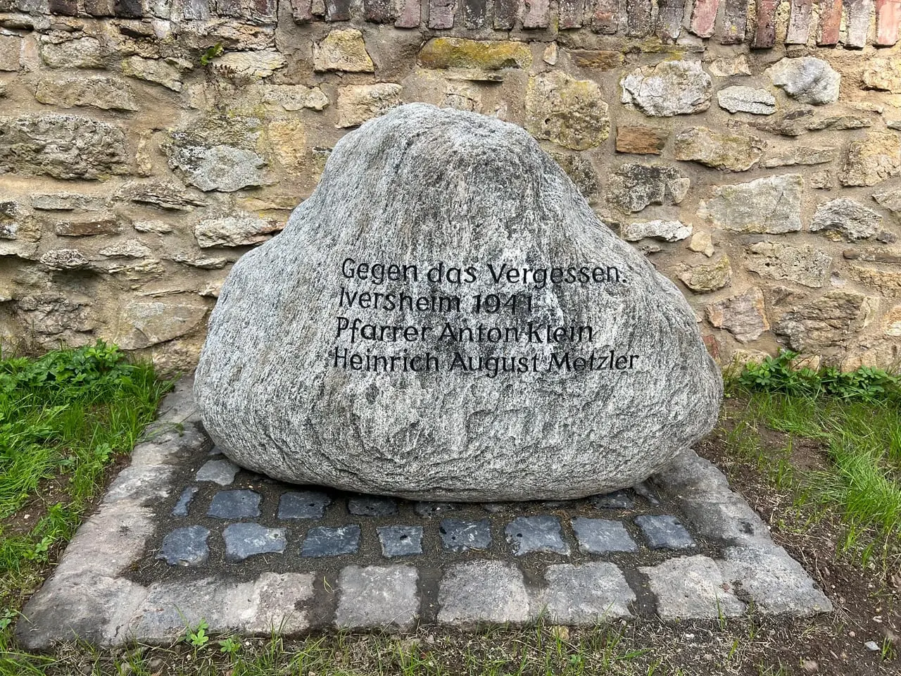 Findling auf dem Friedhof von Iversheim mit der Inschrift „Gegen das Vergessen – 1941 – Pfarrer Anton Klein – Heinrich August Metzler“